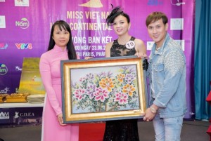 Giám đốc truyền thông – bà Hà Võ và ca sĩ Nguyên Vũ trao cho thí sinh Nguyễn Thị Thùy Dương bức tranh đá quý mà cô đấu giá thành công