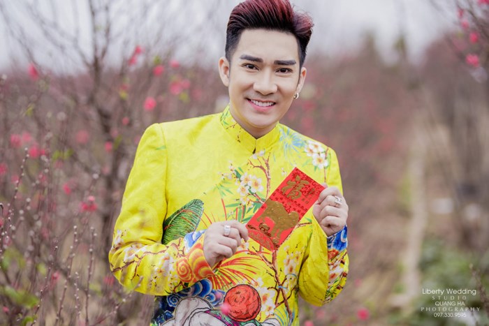 Ca sĩ Quang Hà diện chiếc áo màu vàng rực rỡ sắc xuân giữa đồng hoa đào đang hé nở